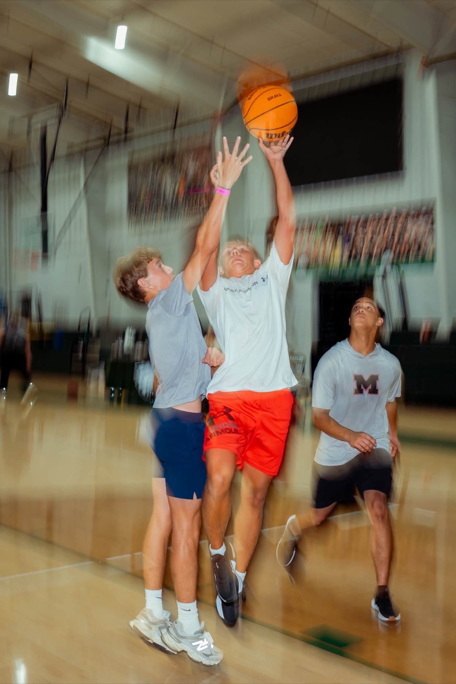 Students playing basketball in the gym on a Wednesday night